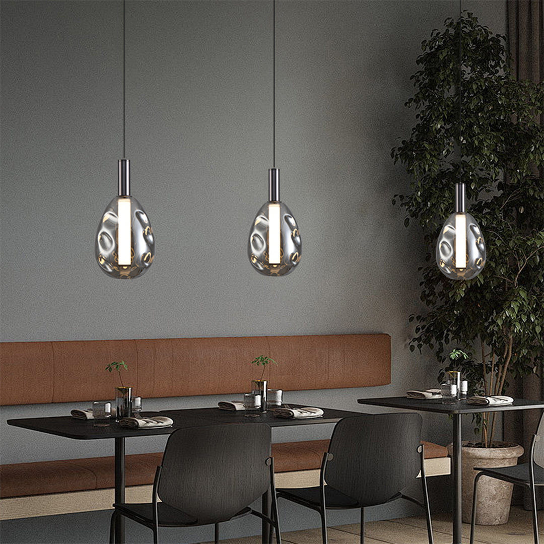 Contemporary drum pendant lights creating ambient lighting in upscale restaurant dining area