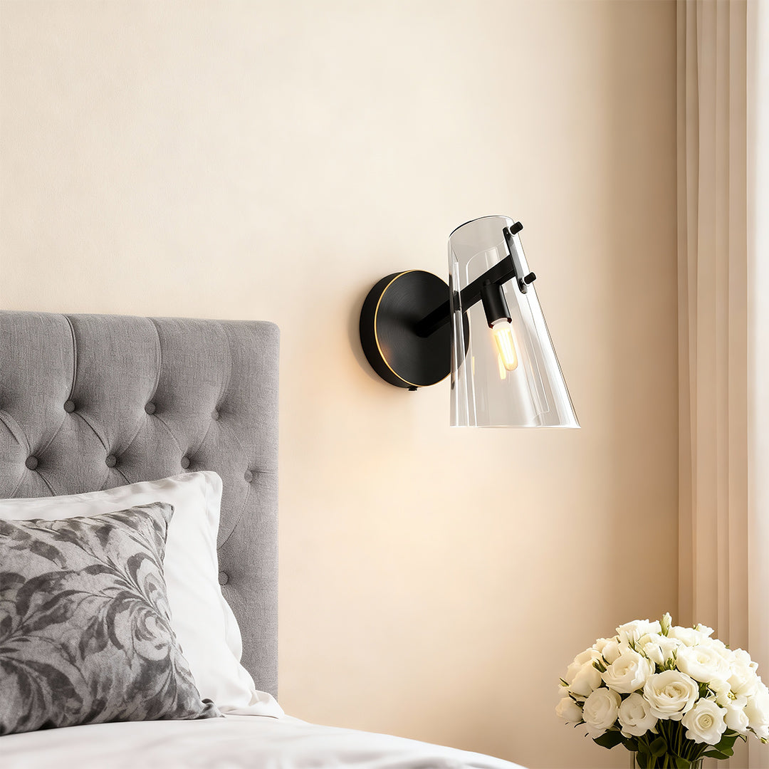 Contemporary wall sconce lighting providing bedside illumination in bedroom with tufted headboard