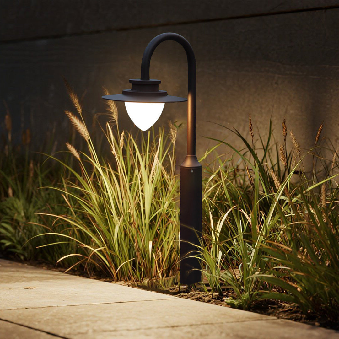 Contemporary landscape design featuring shepherd's hook lights creating ambient illumination in garden beds