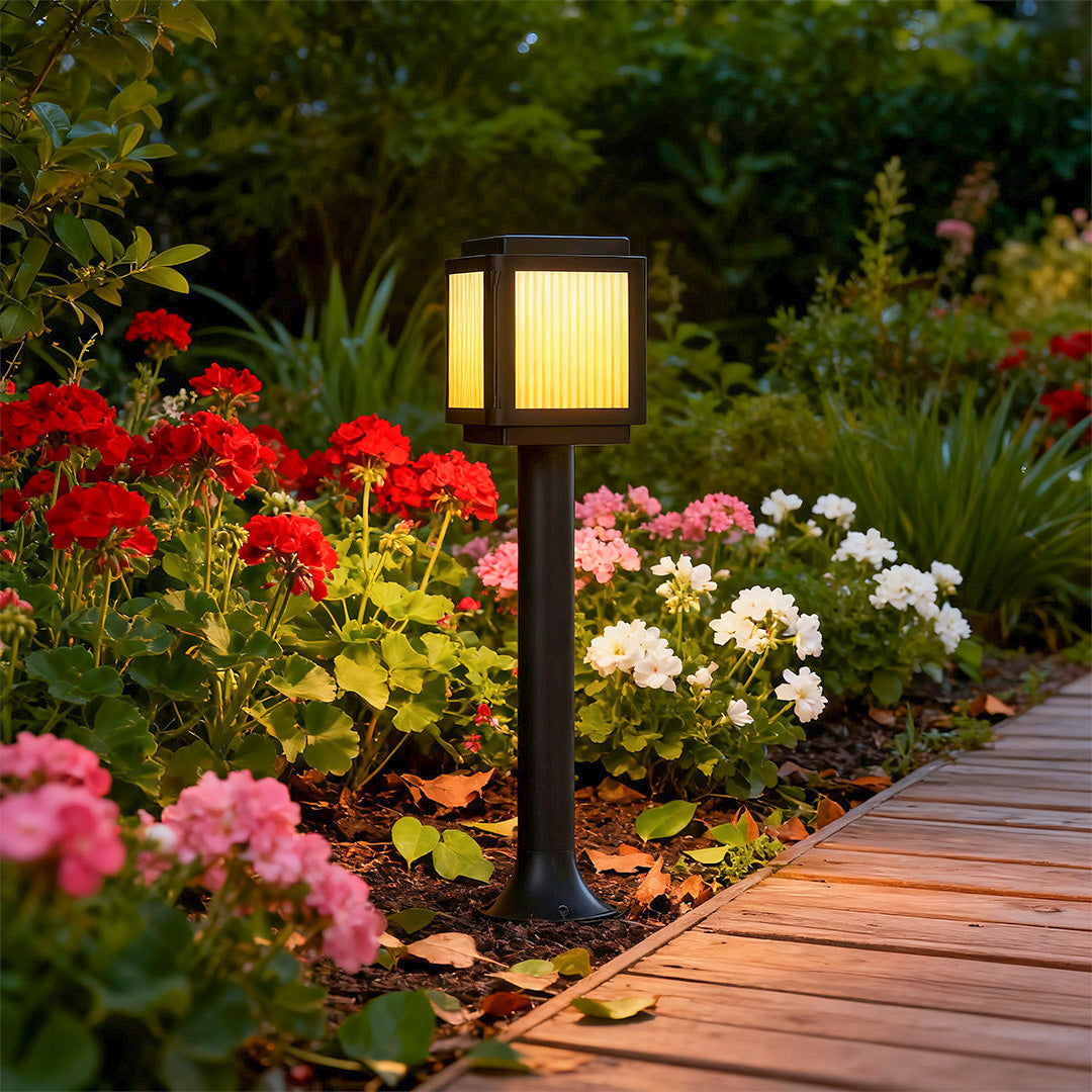 Contemporary solar path light placed near a flower bed, enhancing the garden ambiance with subtle lighting.