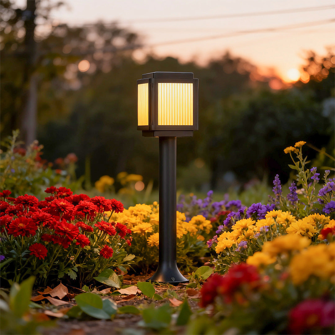 Contemporary solar path light along a garden pathway surrounded by colorful flowers, offering stylish and functional lighting.