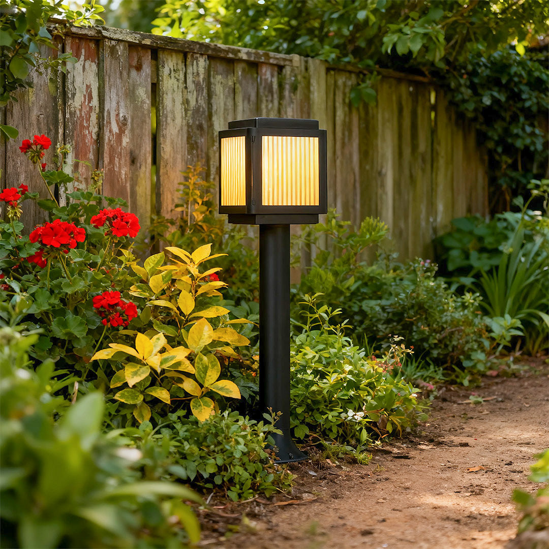 Contemporary solar path light in a garden with vibrant flowers, adding a modern touch to the outdoor space.