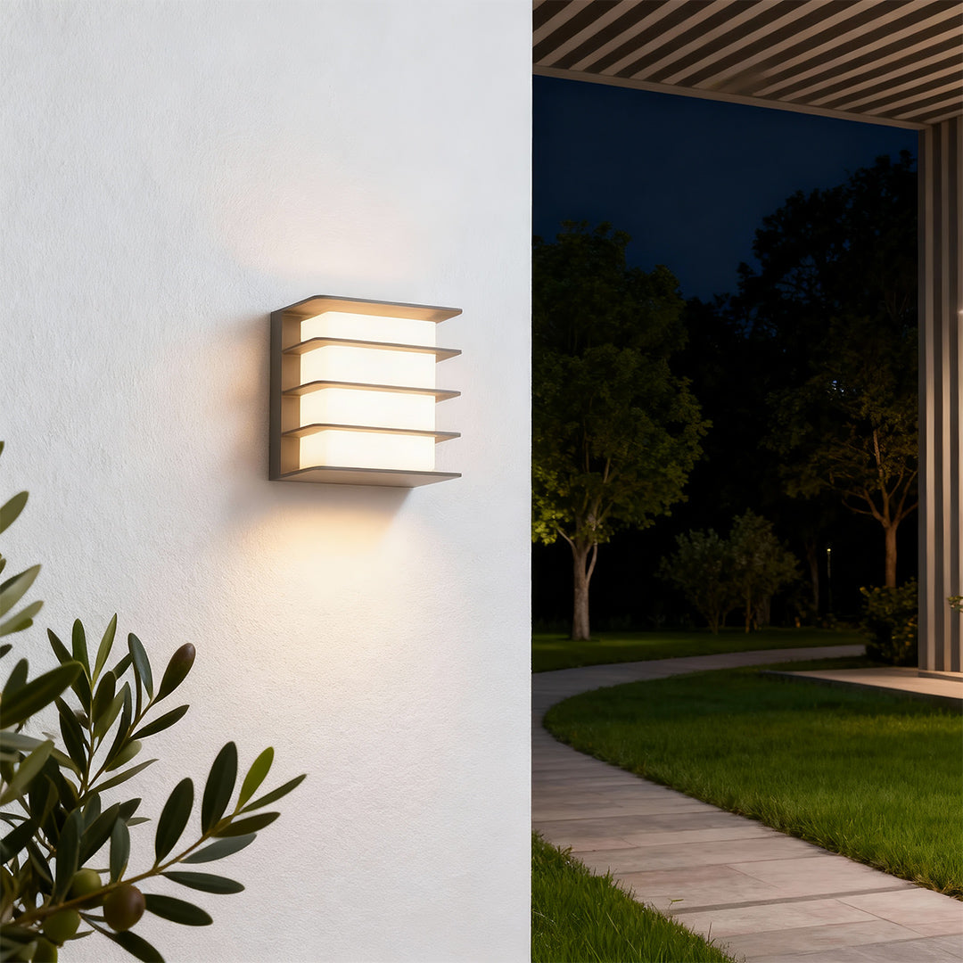 Contemporary square LED wall lights featuring glass shade chandelier styling creating warm ambient glow on interior and exterior walls.