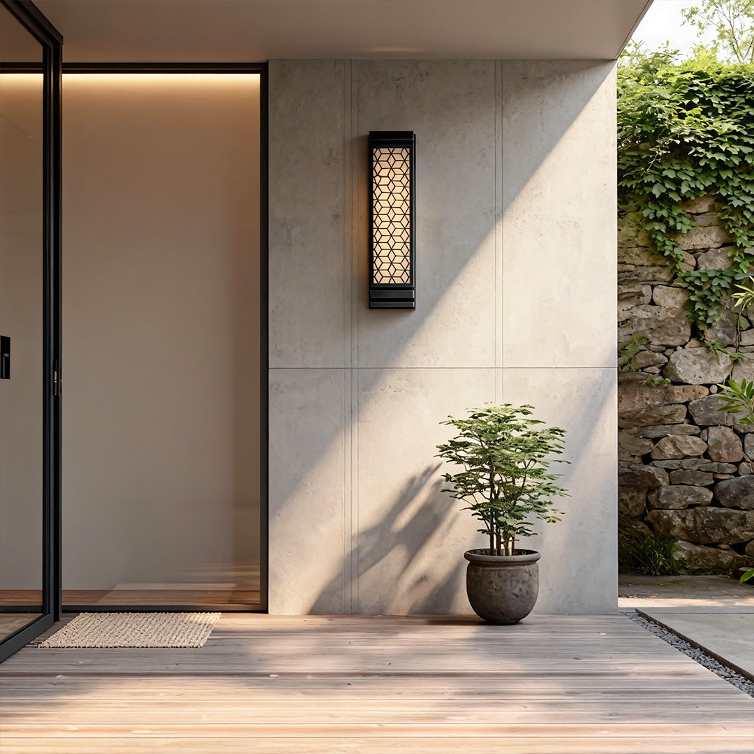 Contemporary square wall sconce light illuminating a white exterior wall, adding a touch of modern sophistication.