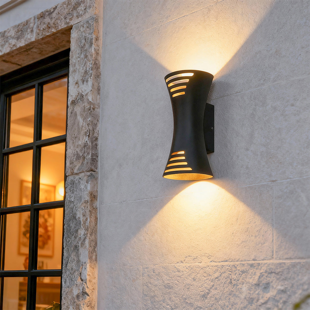 Contemporary up down lighting wall sconce featuring glass shade chandelier styling creating dramatic light spread on stucco facade.