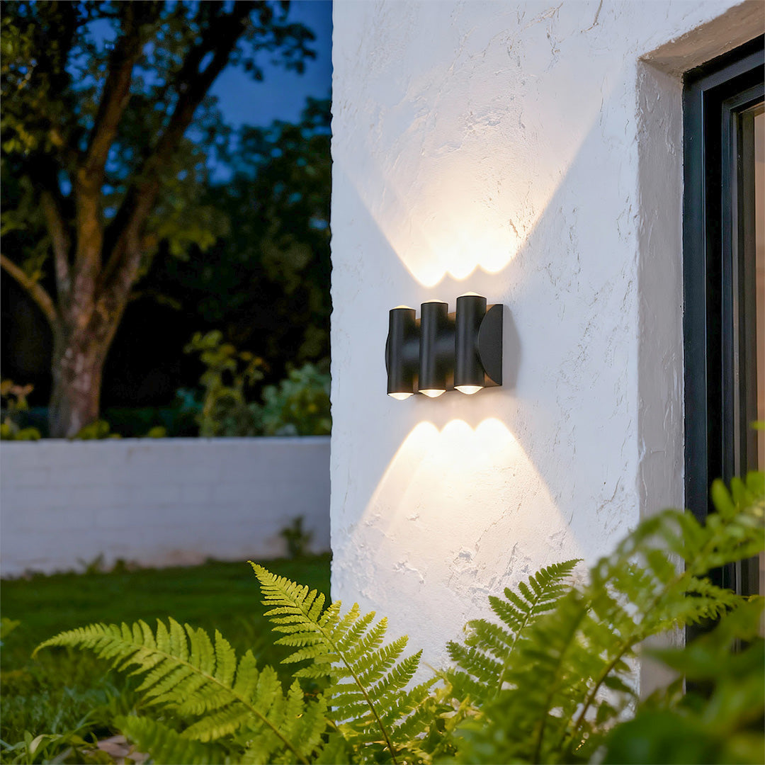 Contemporary up down lighting wall lights featuring glass shade chandelier styling creating dramatic bidirectional illumination on white exterior.