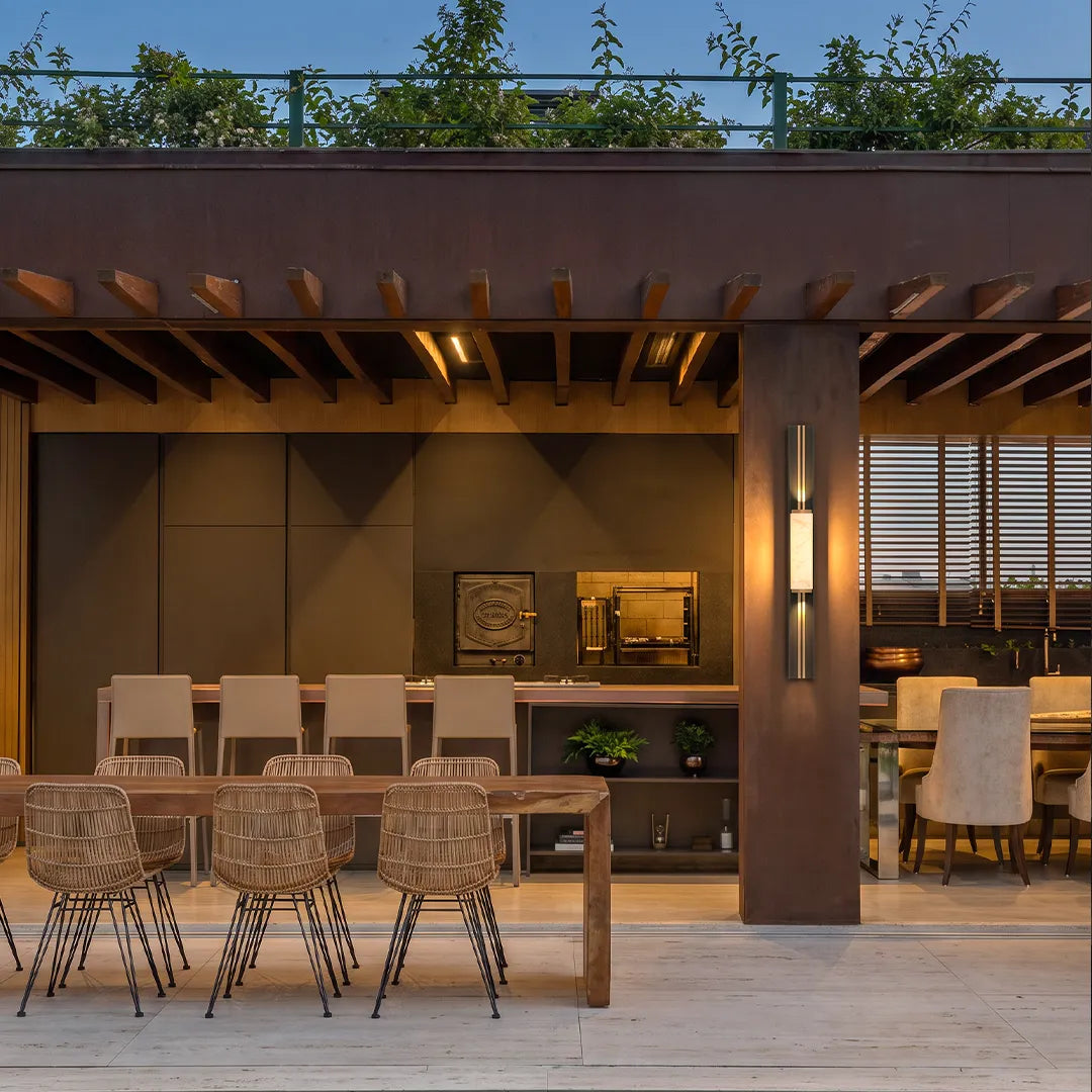 Contemporary wall light fixtures illuminating a covered outdoor kitchen and dining area.
