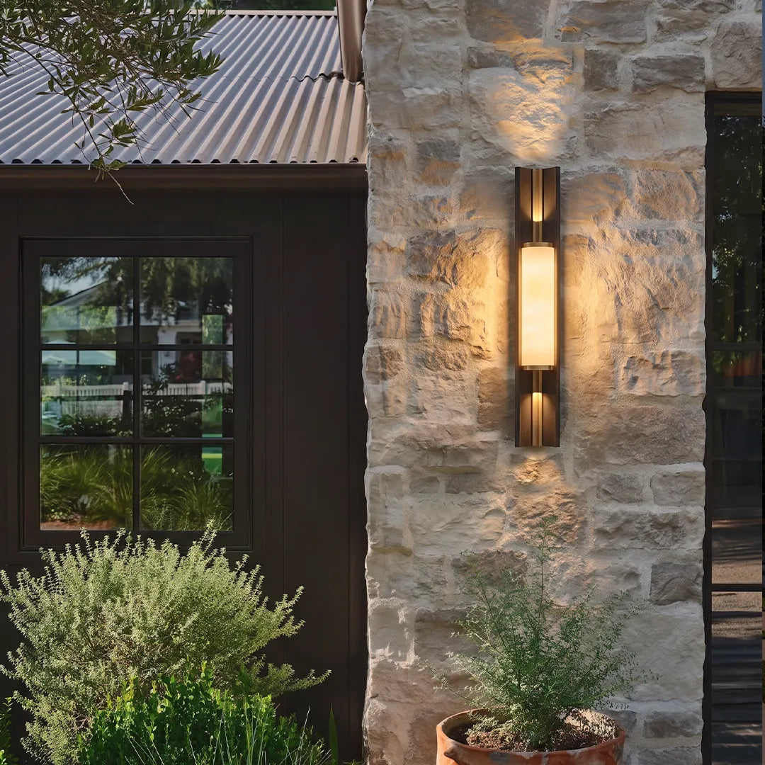 Contemporary wall light fixtures mounted on a stone exterior wall with warm vertical illumination.