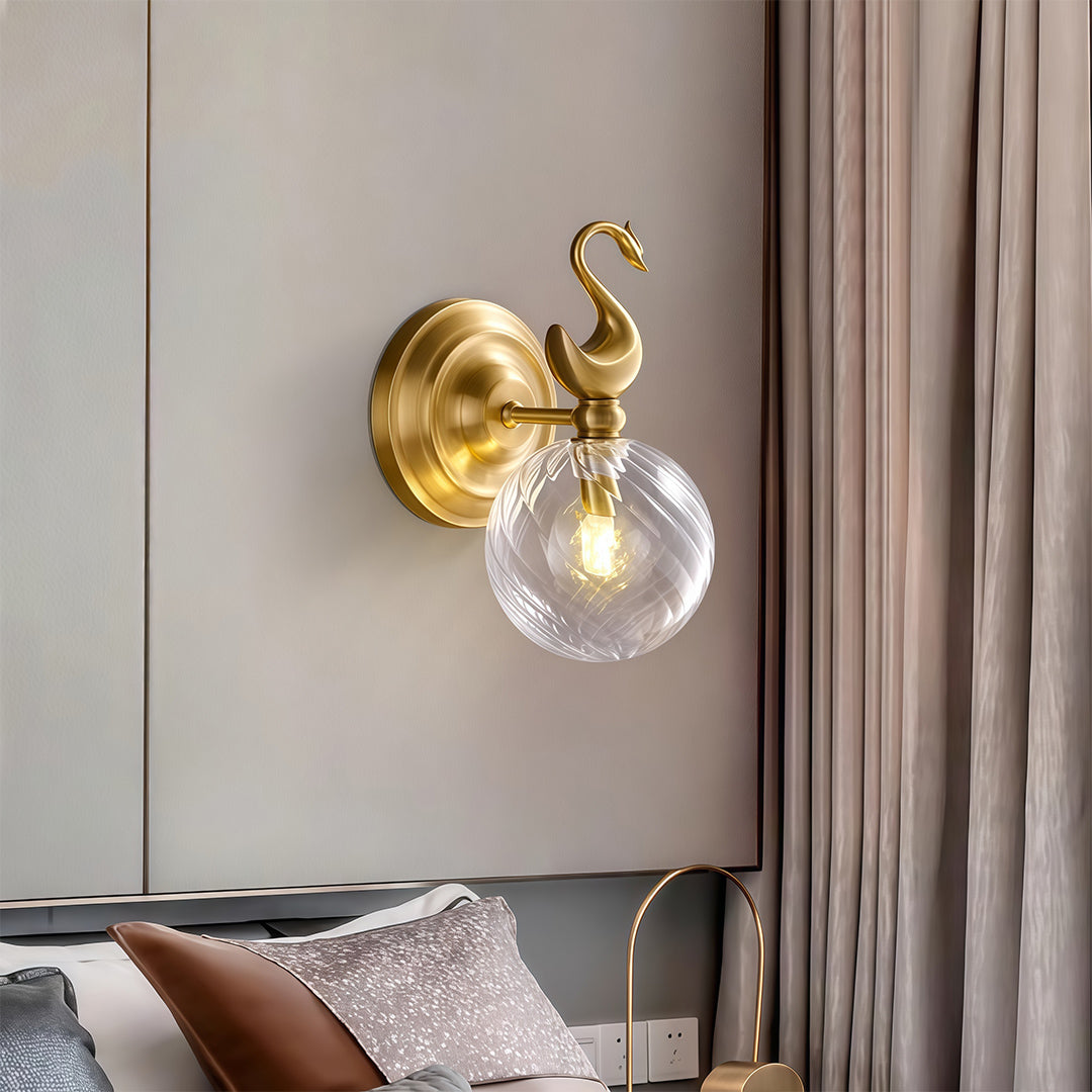 Contemporary wall mounted LED light with glass shade chandelier styling illuminating bedroom above nightstand with decorative animal accent.