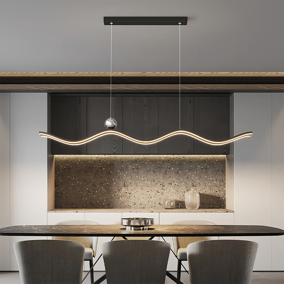 Contemporary linear led pendant light featuring a dynamic wave shape and integrated LED, installed above a stone countertop table.