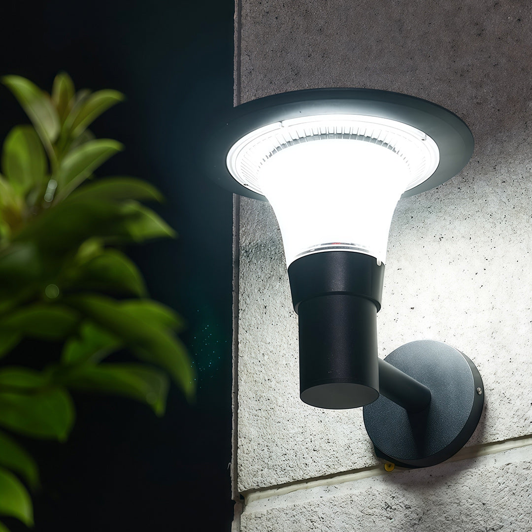 Cool white light version of the outdoor solar wall sconce shown illuminating a dark wall at night.