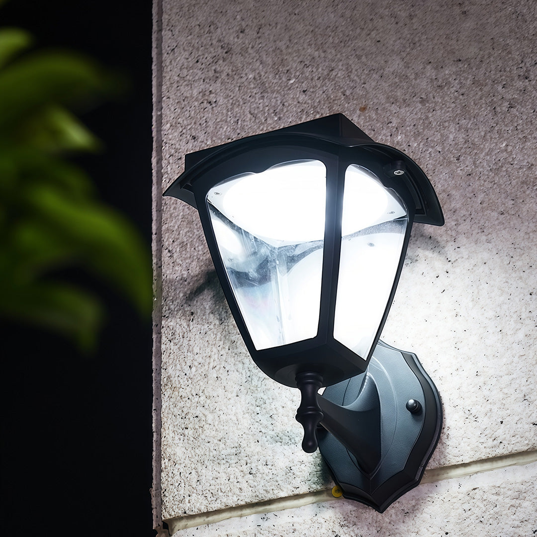 Cool white outdoor wall lighting black fixture glowing brightly on a textured stone wall at night.