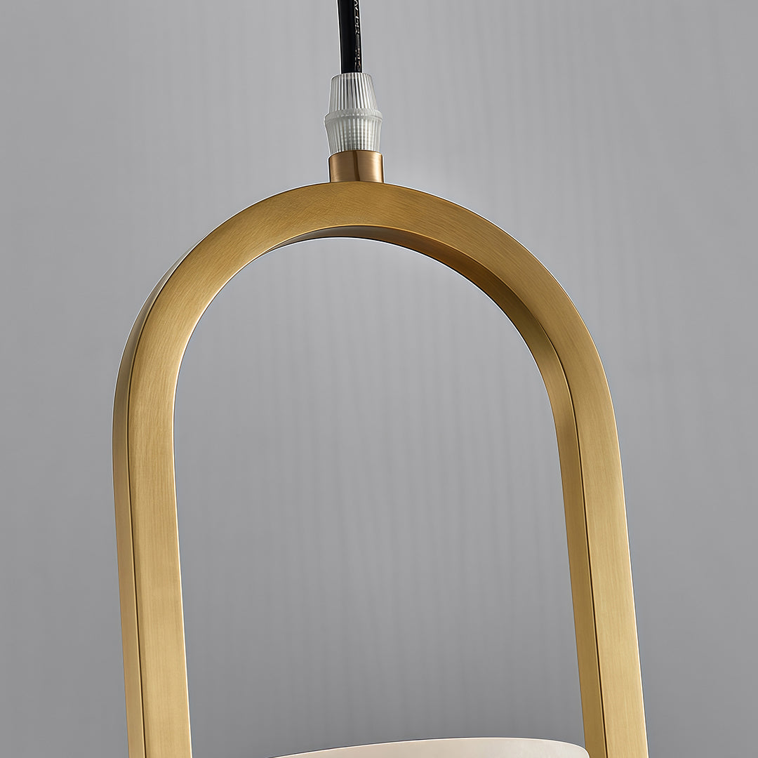 Close-up of copper hanging pendant lights showing curved brass frame and textured metallic finish detail