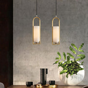 Pair of copper hanging pendant lights over dining area with matching brass finish and minimalist design