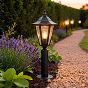 Copper landscape path lights lining a curved gravel path, creating a warm and inviting outdoor landscape lighting effect.