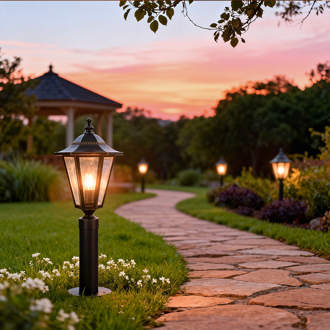 Copper landscape path lights illuminating a winding stone pathway at sunset, enhancing garden ambiance and visibility.