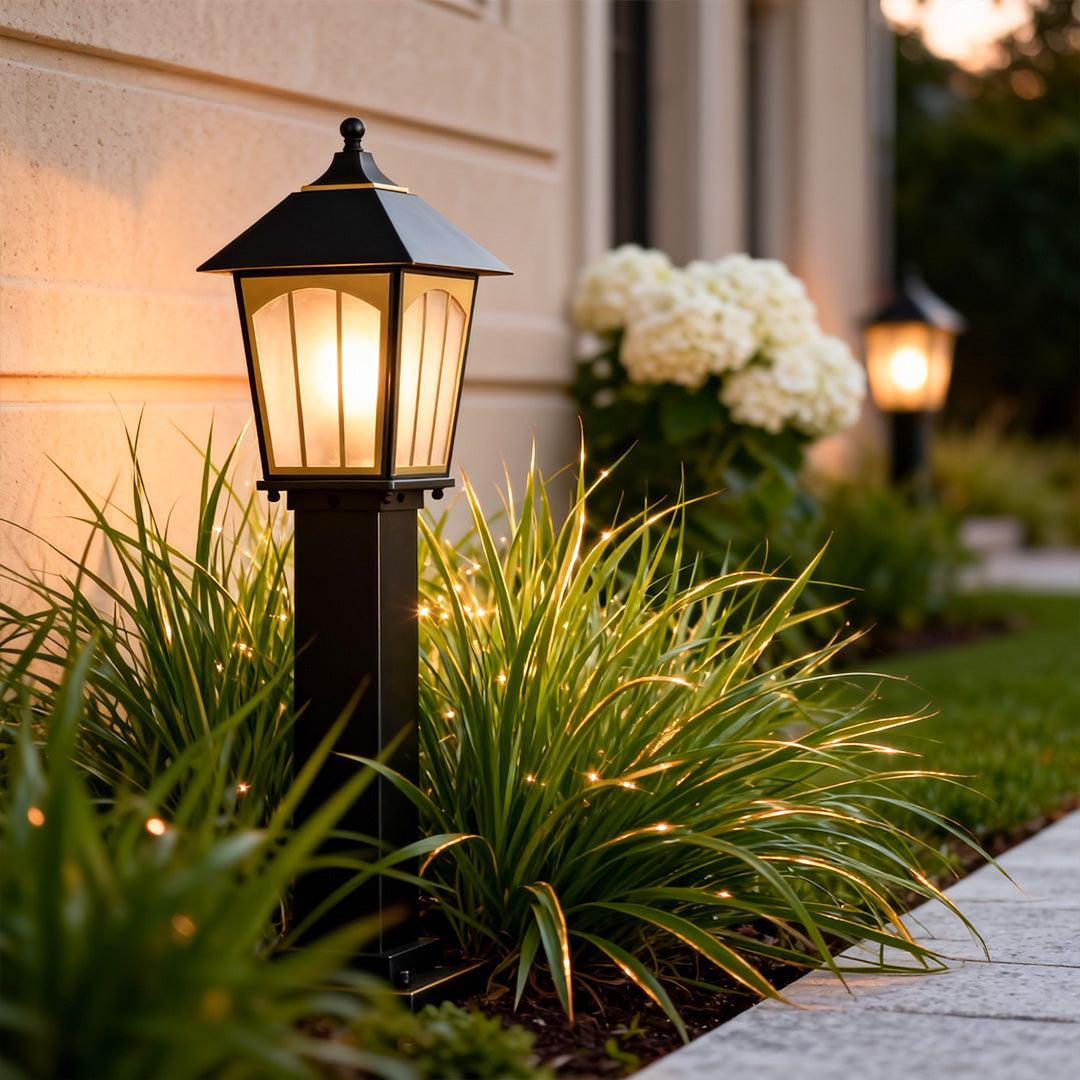 Copper LED path lights installed along a landscaped garden edge, providing warm illumination beside plants and shrubs.