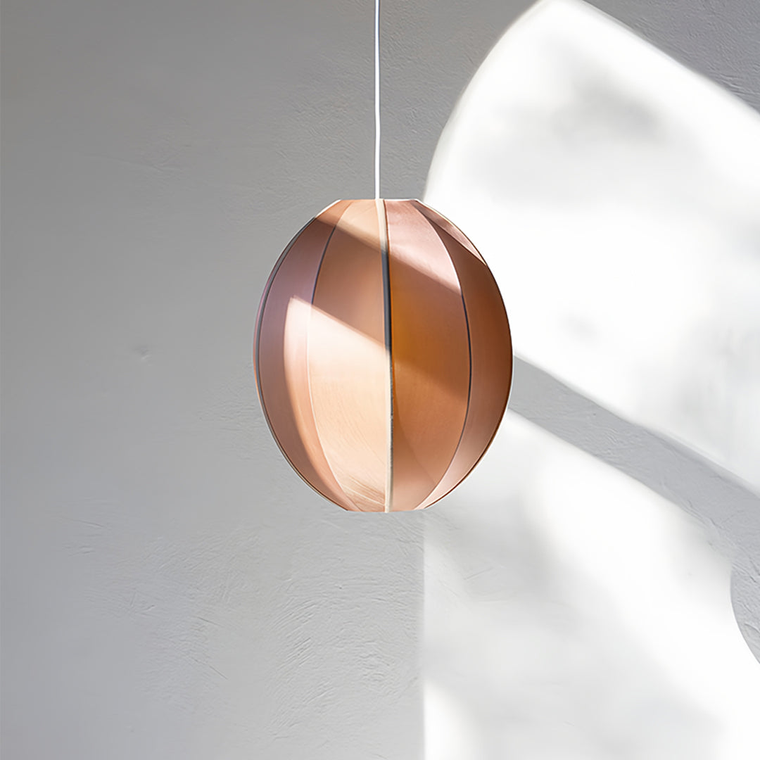 Copper fabric shade pendant light with warm metallic glow in minimalist interior setting