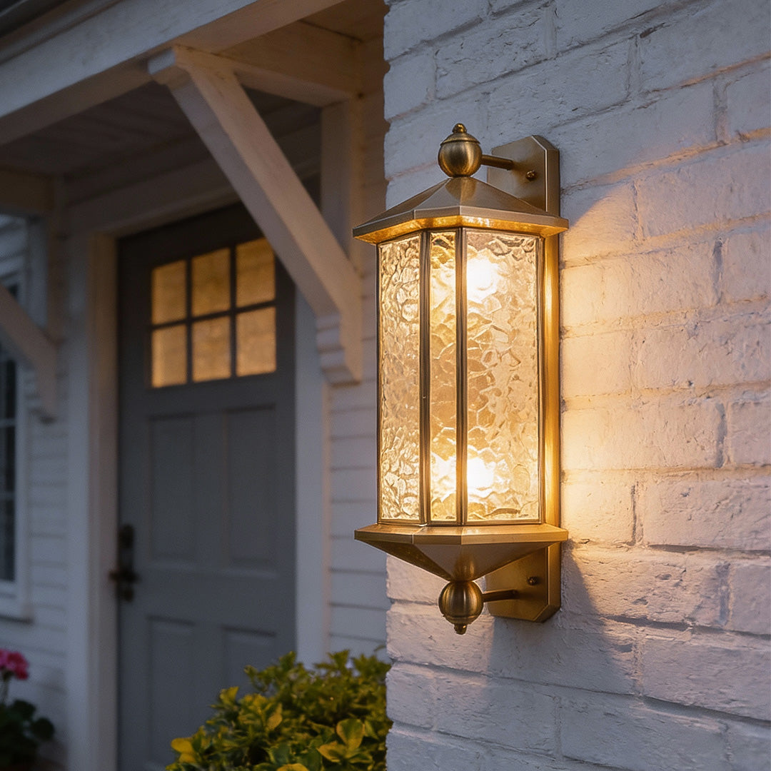 Copper outdoor wall lantern installed beside a front door, featuring textured glass and a classic vertical lantern silhouette.