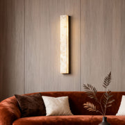 Copper sconce indoor with a sleek rectangular design, illuminating a cozy living room.