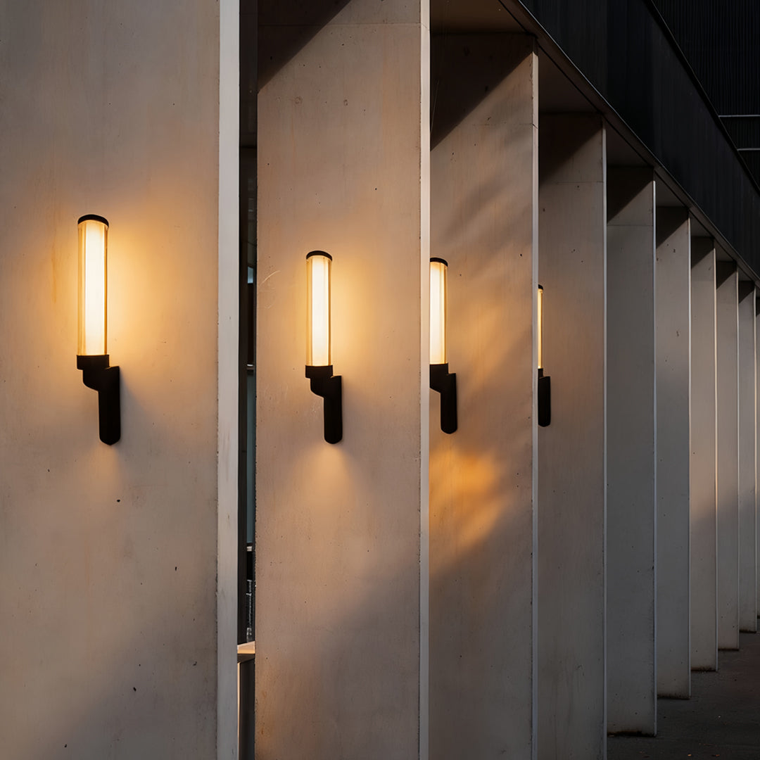 Row of slim vertical outdoor sconces modern lining a corridor wall with warm ambient illumination.