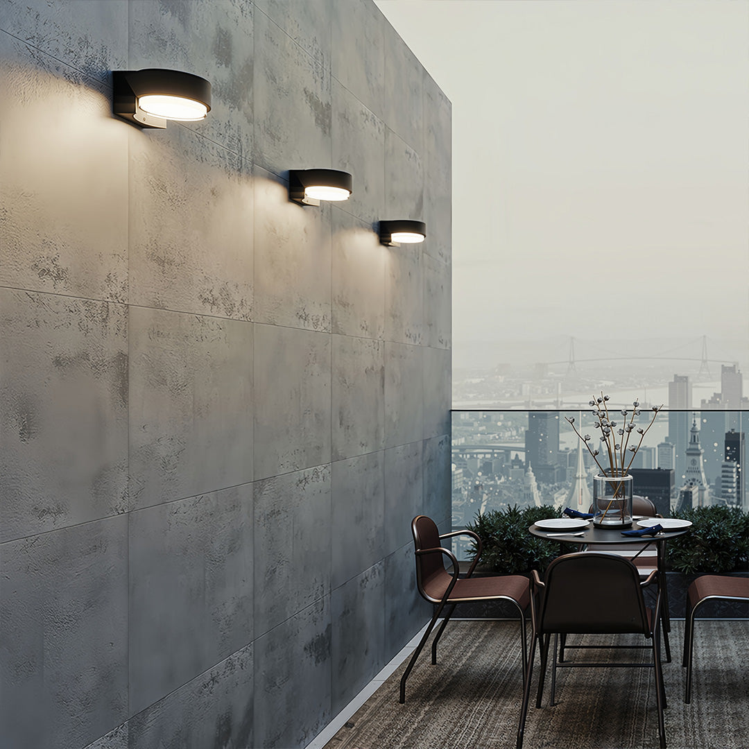 Row of minimalist lights for outdoor wall casting warm ambient glow on a textured exterior corridor.
