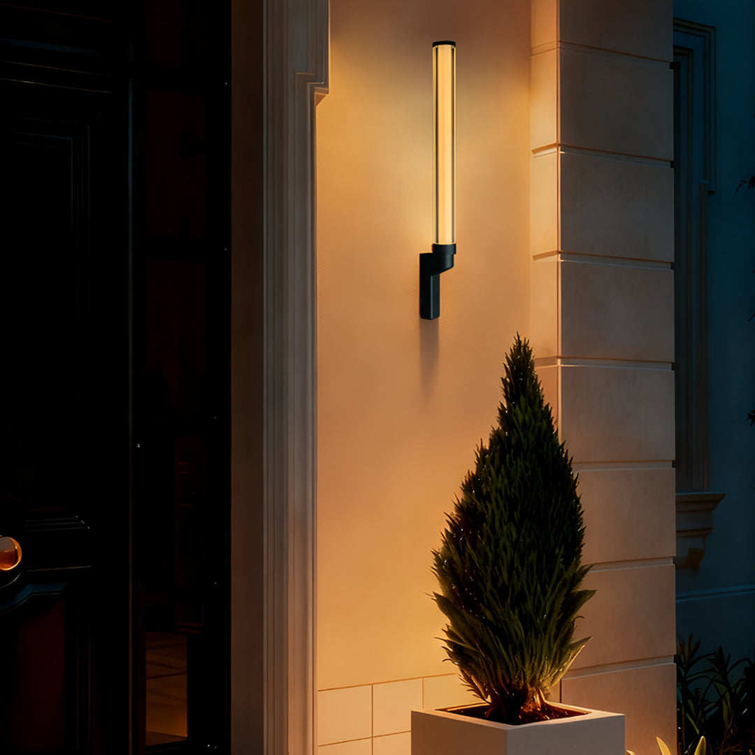 Soft warm outdoor sconces modern lighting up a bright white exterior wall in an outdoor courtyard.