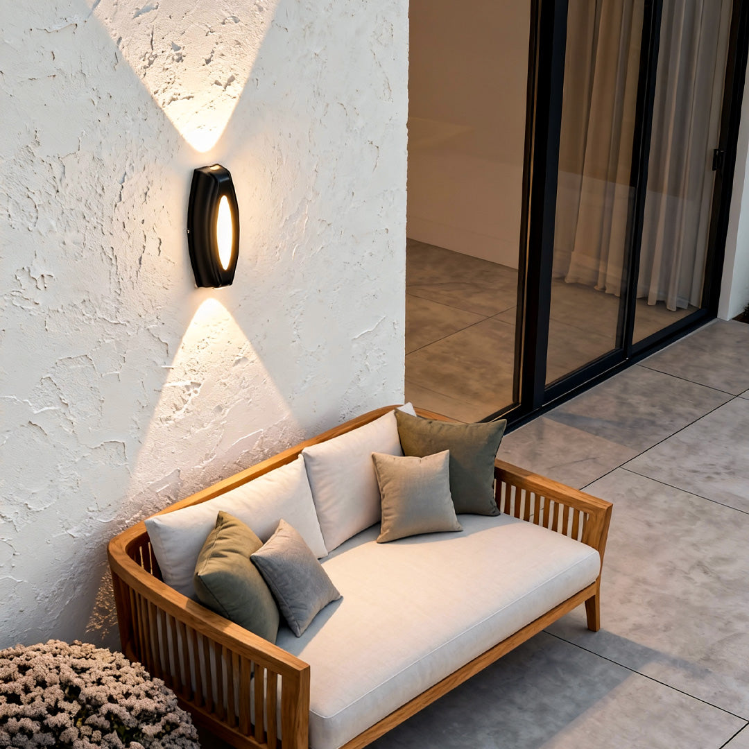 Contemporary outside up down wall lights enhancing a cozy outdoor lounge with soft ambient illumination.