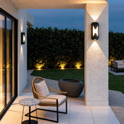 Up down outdoor wall light illuminating a cozy outdoor seating space with soft warm light.