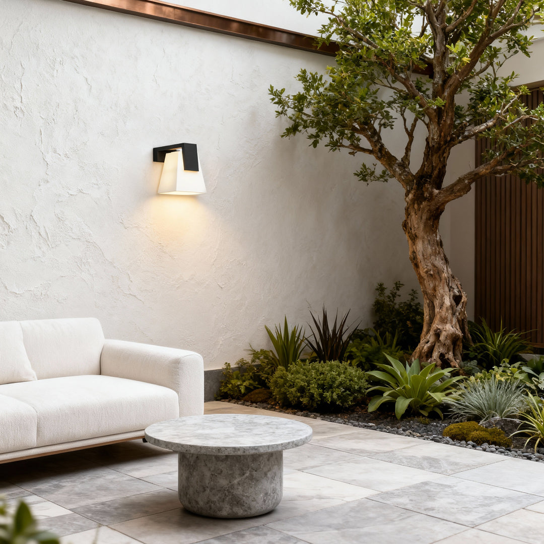 Modern wall mounted outdoor lights illuminating a cozy outdoor seating nook with warm light.