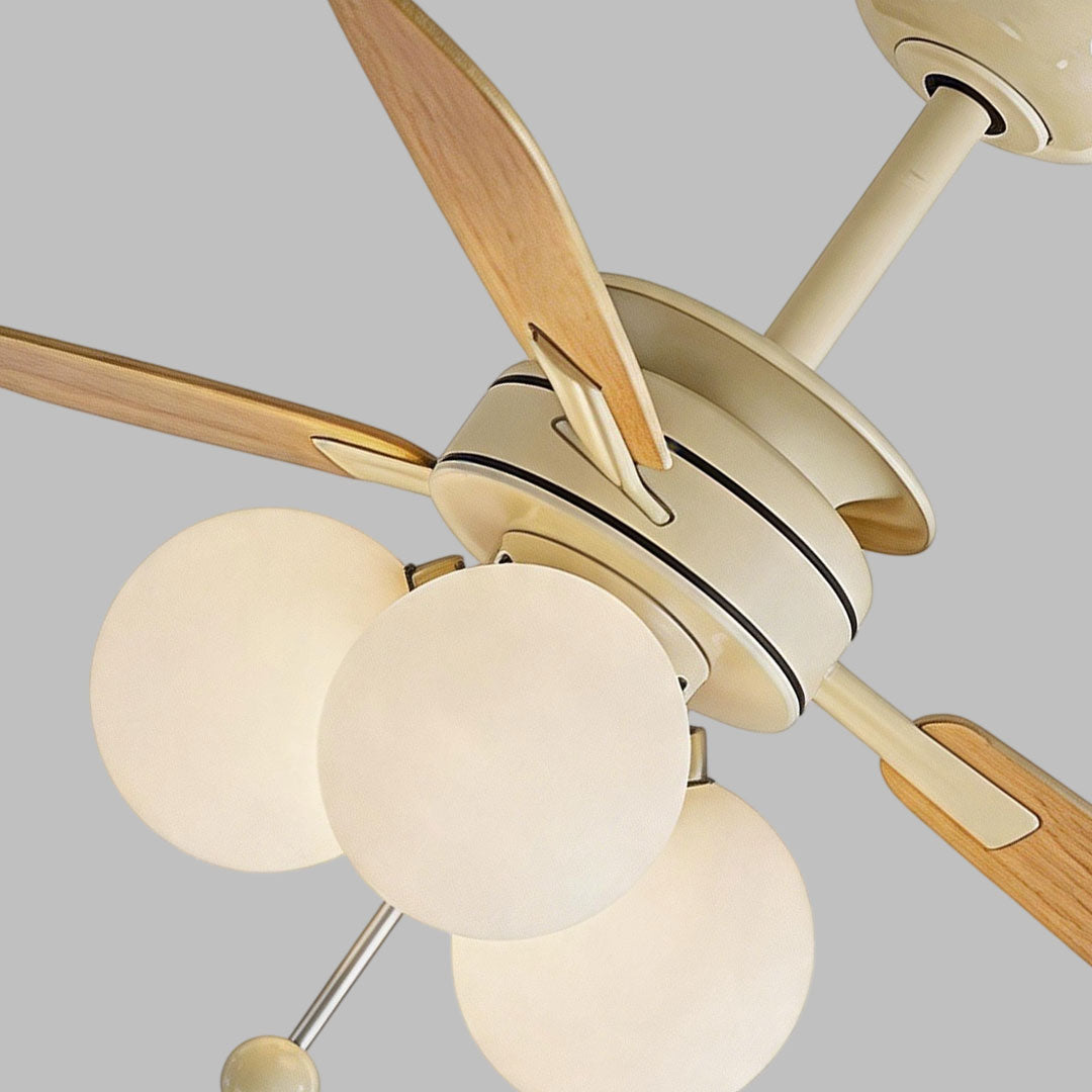 Close-up of indoor ceiling fan with light showing the cream motor housing and frosted globe shades.