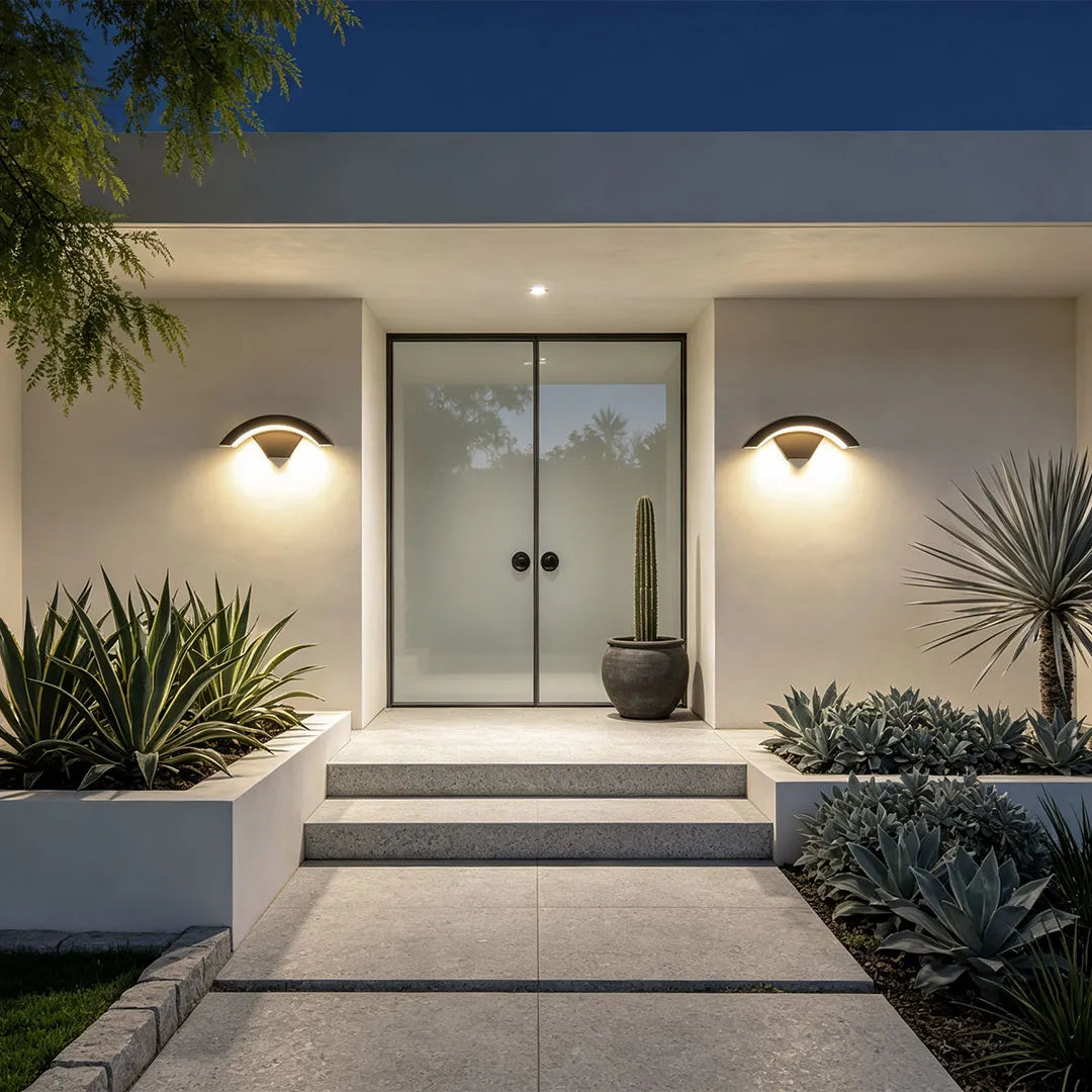 Creative moon curved wall sconces flanking a minimalist front entrance with soft warm lighting.