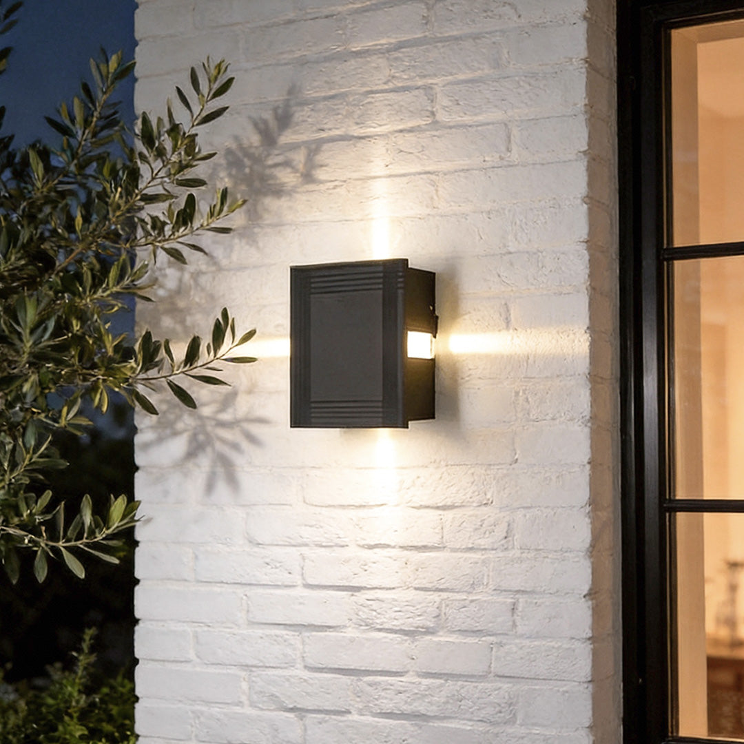 Cross light beams wall sconce illuminating a modern outdoor wall with warm, directional glow.