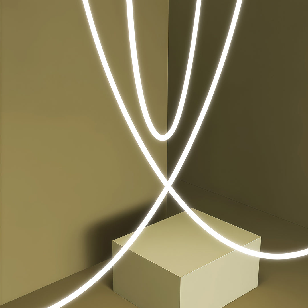 Crossed neon pendant lights with X-shaped composition casting soft white light on olive wall.