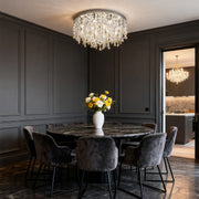 Unique crystal chandelier creating ambient lighting in dramatic dark contemporary dining space