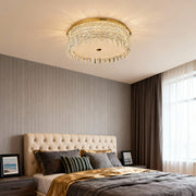 Crystal flush mount ceiling light in modern bedroom decor with headboard.