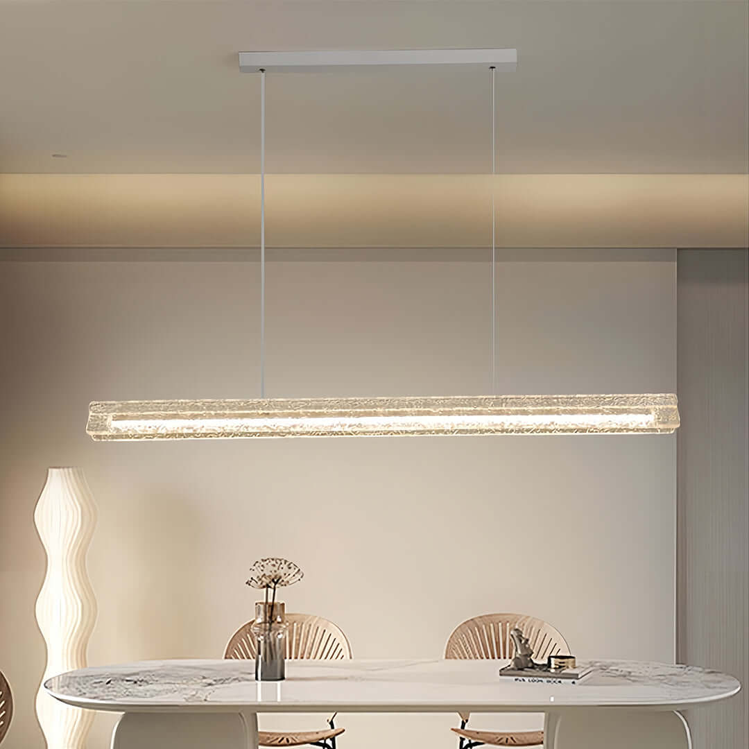 Crystal linear modern white pendant light illuminating a marble dining table in a contemporary dining room.