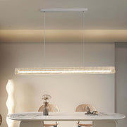 Crystal linear modern white pendant light illuminating a marble dining table in a contemporary dining room.