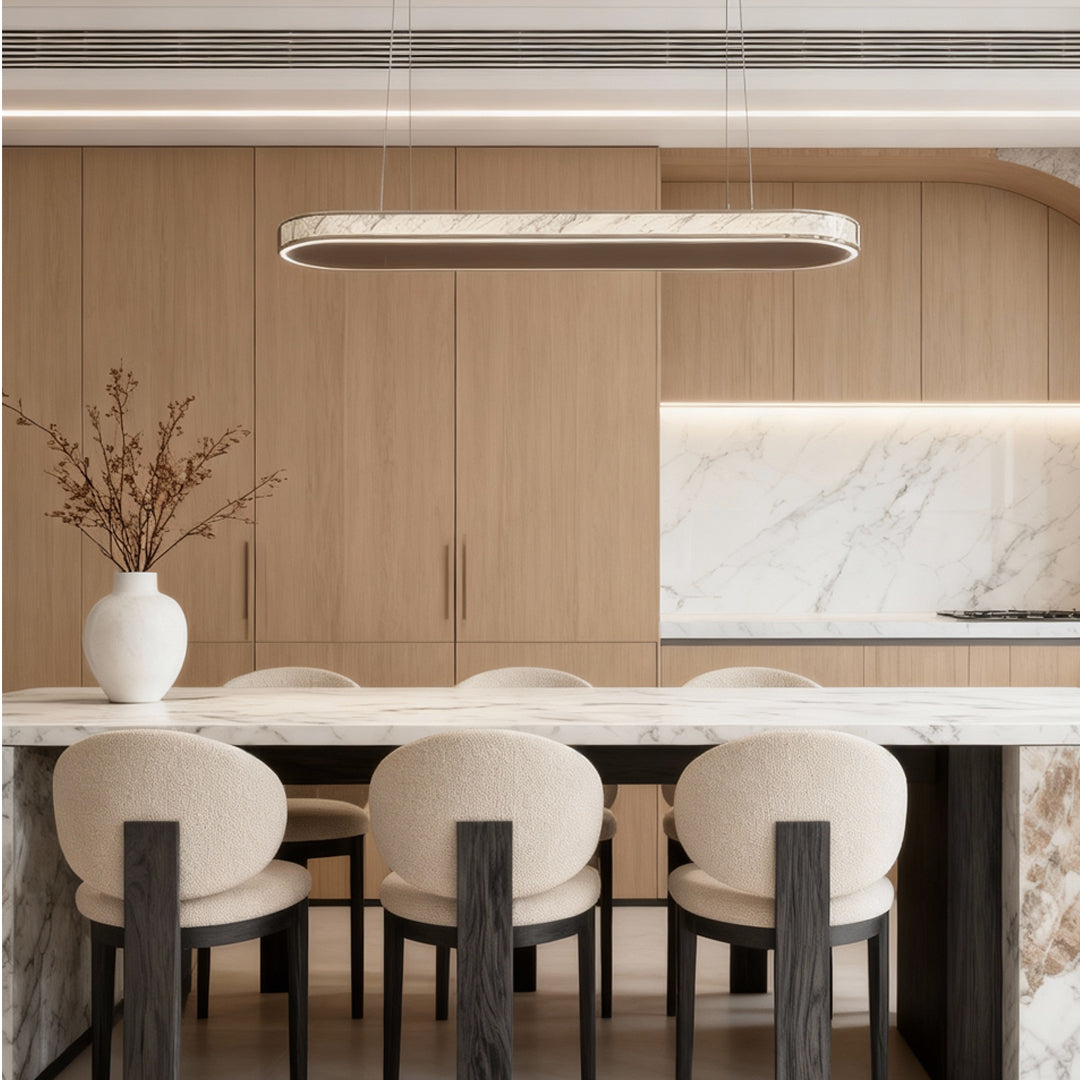 Modern crystal pendant light illuminating a warm-toned dining area with neutral textures.