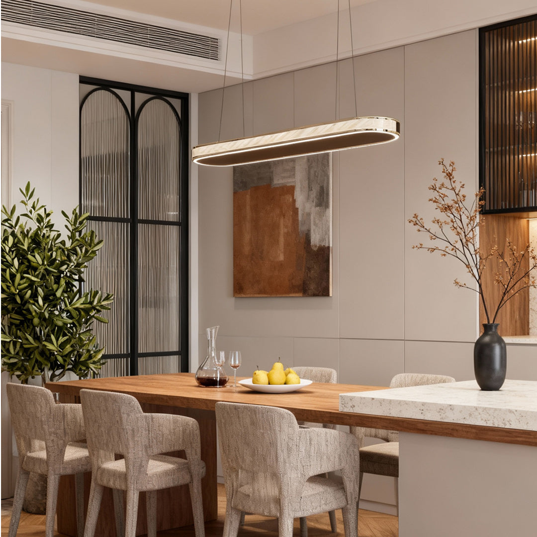 Slim crystal-accent linear pendant light installed above a minimalist dining bar with neutral decor.