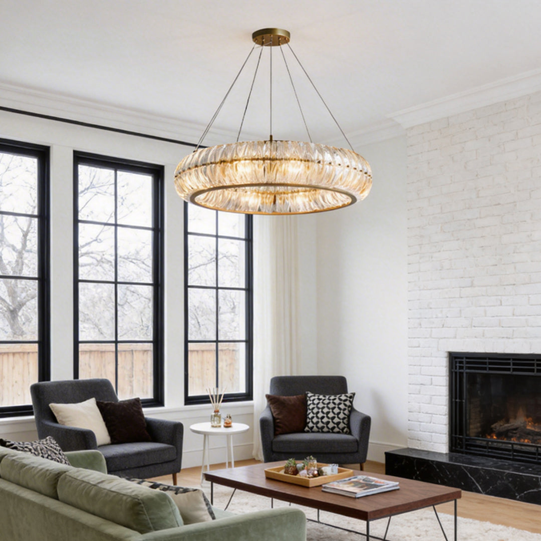 Crystal ring chandelier hanging in a modern living room with large windows and a fireplace.