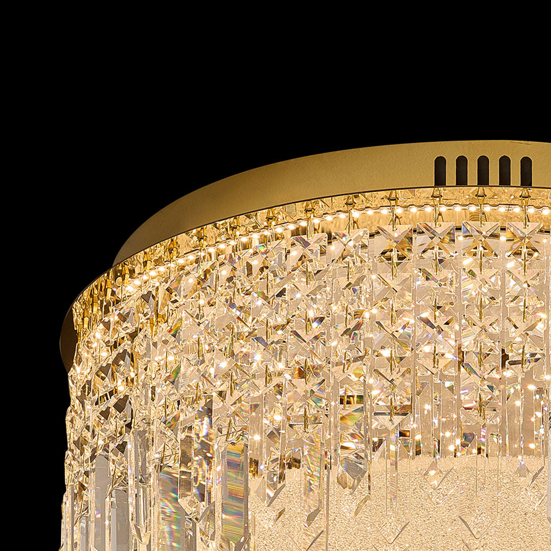 Close-up of crystal round flush mount ceiling light with gold rim.