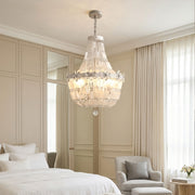 Crystal vintage chandelier installed in an elegant bedroom with warm sparkling illumination.