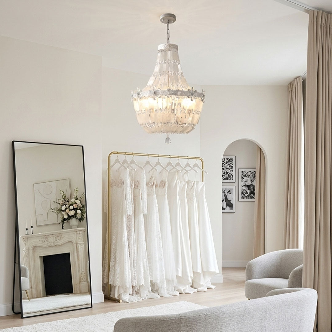 Crystal vintage chandelier hanging above a clothing display with bright decorative crystal lighting.