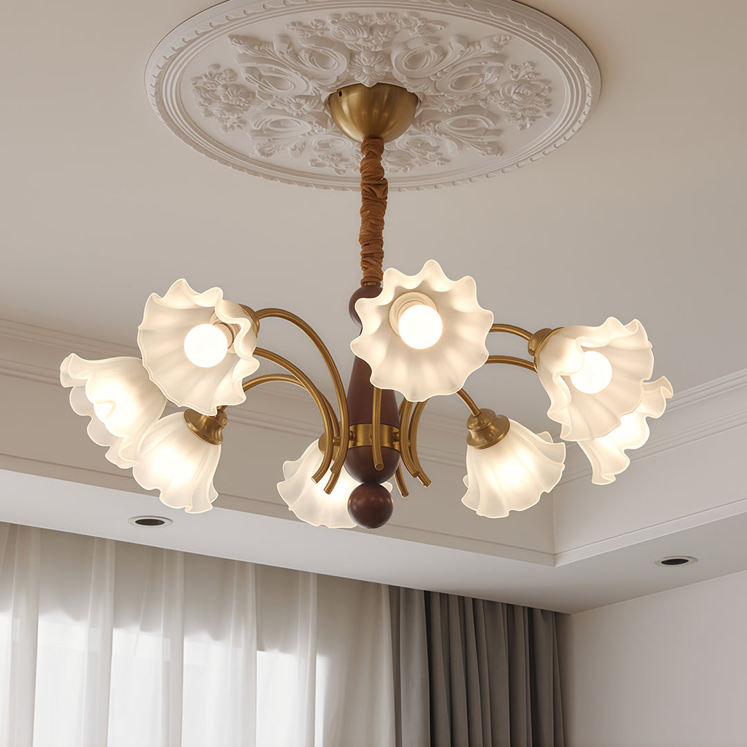 Crystal vintage chandelier providing warm lighting in contemporary bedroom with grey curtains and decorative ceiling rosette.