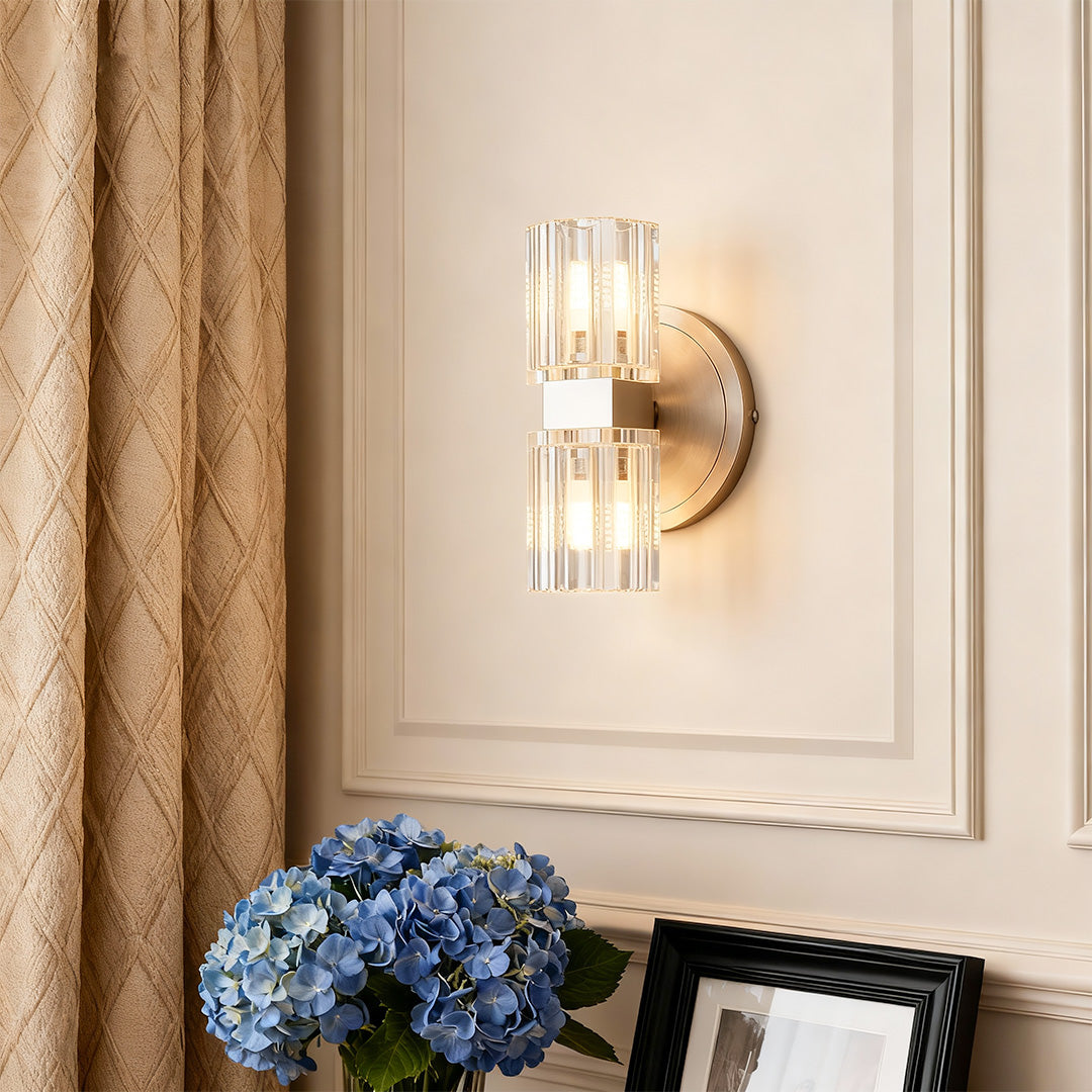 Crystal wall light illuminating elegant bedroom with paneled walls and traditional furniture