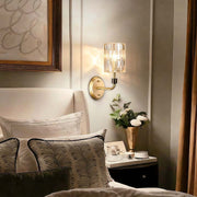 Crystal wall lights gold with elegant crystal columns, illuminating a cozy bedroom corner.