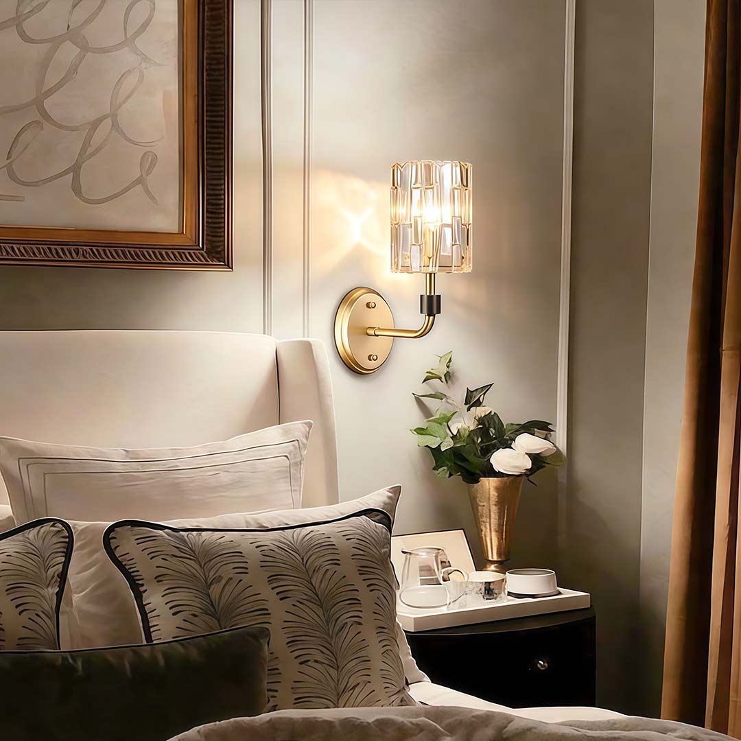 Crystal wall lights gold with elegant crystal columns, illuminating a cozy bedroom corner.