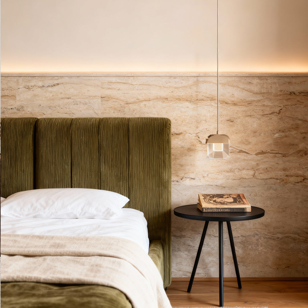 Minimalist bedroom with suspended crystal wall sconce lighting above a black round nightstand.