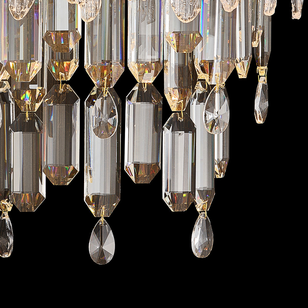 Close-up of crystal wall sconce showing faceted glass prisms and gold metal details.